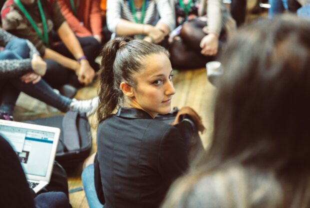 A photo of people sat on the floor at an event about public services