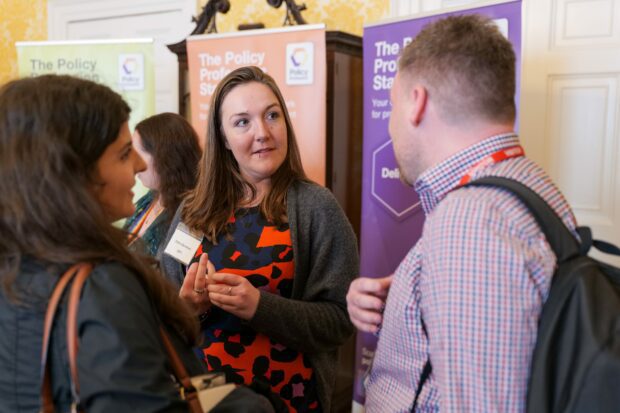 A photo of people in conversation at an event about policymaking.