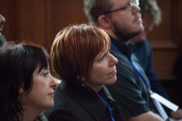 A photo of people listening to other people speak at an event about public services.